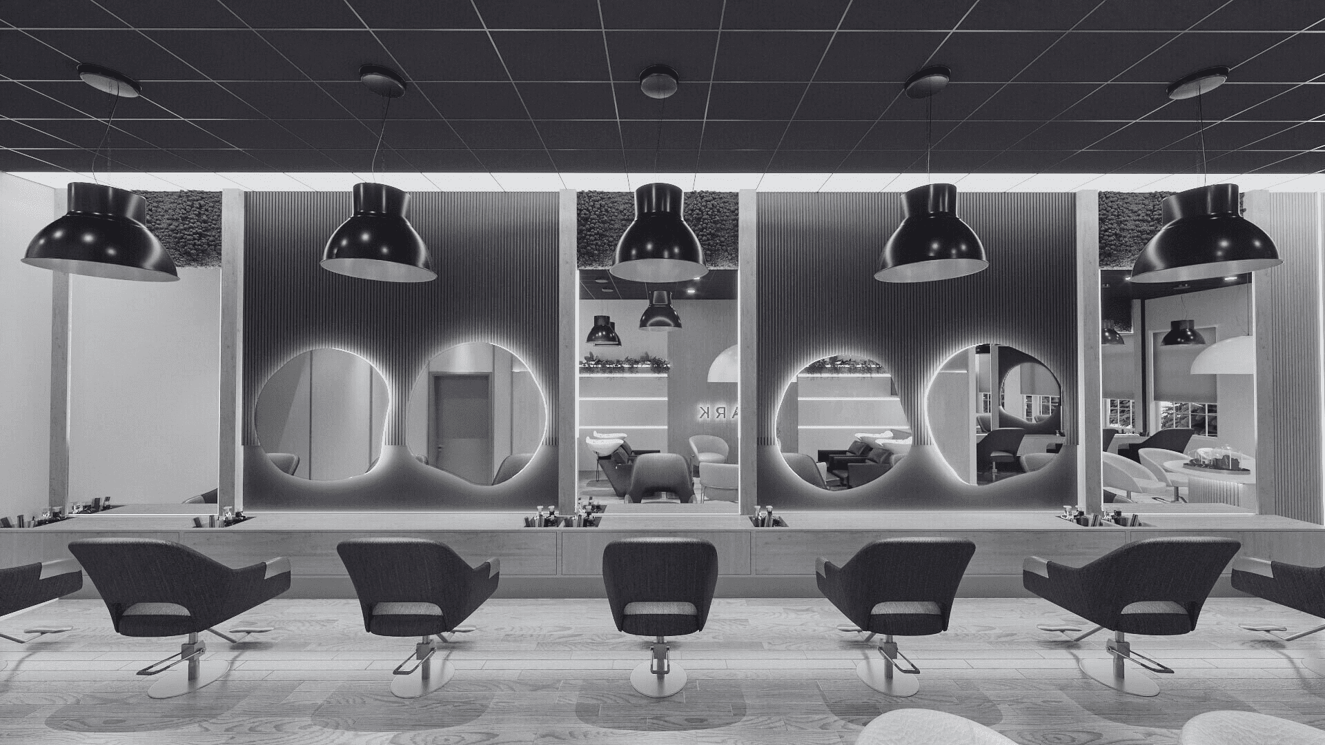 Modern salon with stylish chairs and large mirrors, featuring sleek hanging lights.