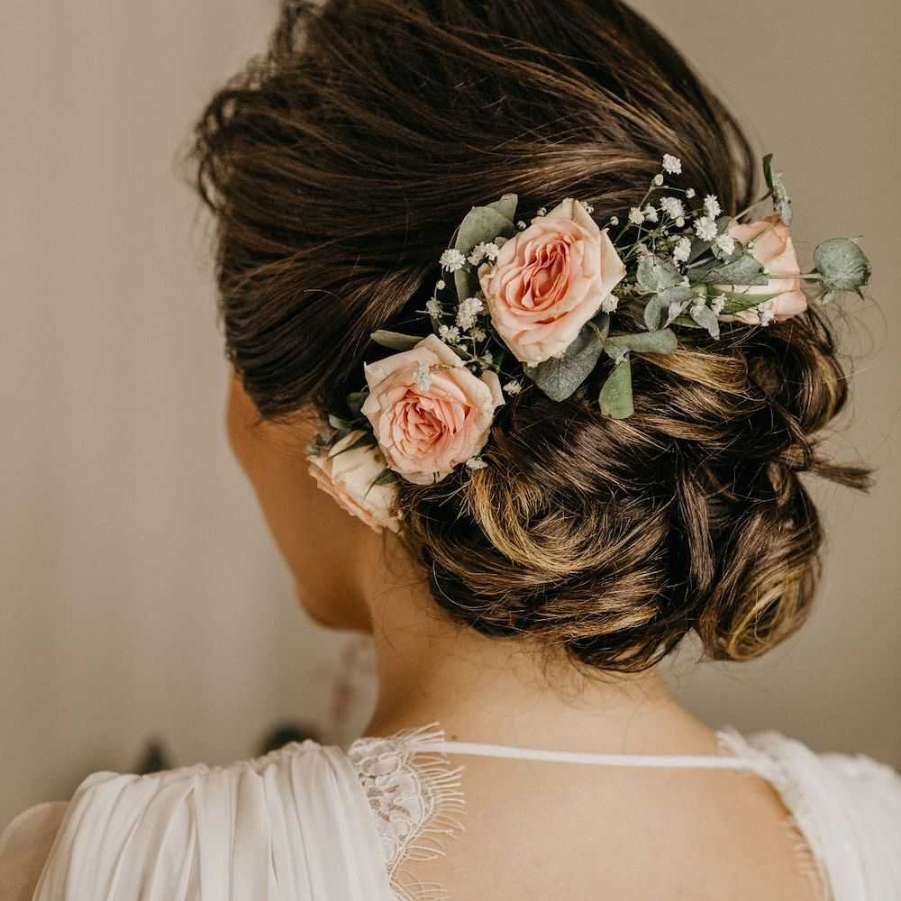 Bride with a floral hairpiece featuring roses and baby's breath.