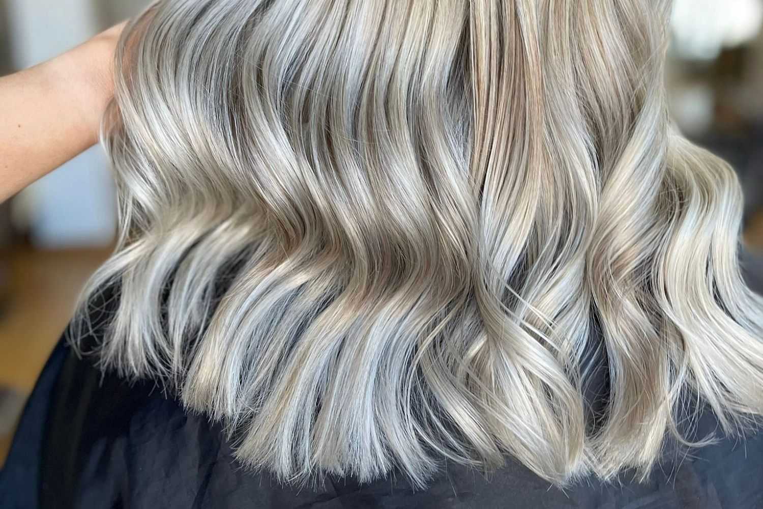 Woman with stylish wavy silver and ash blonde hair.