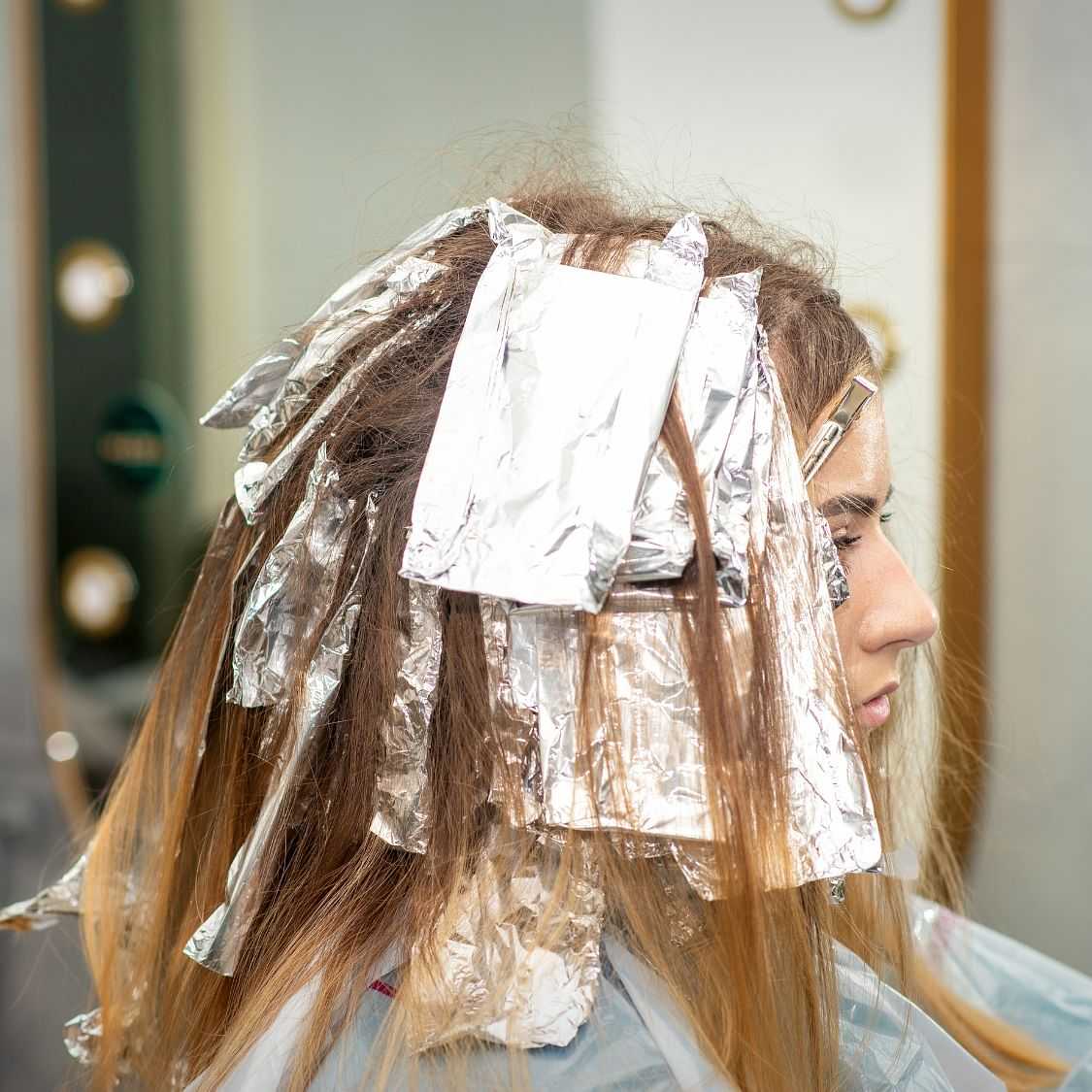 Woman getting her hair colored at a salon with foils.