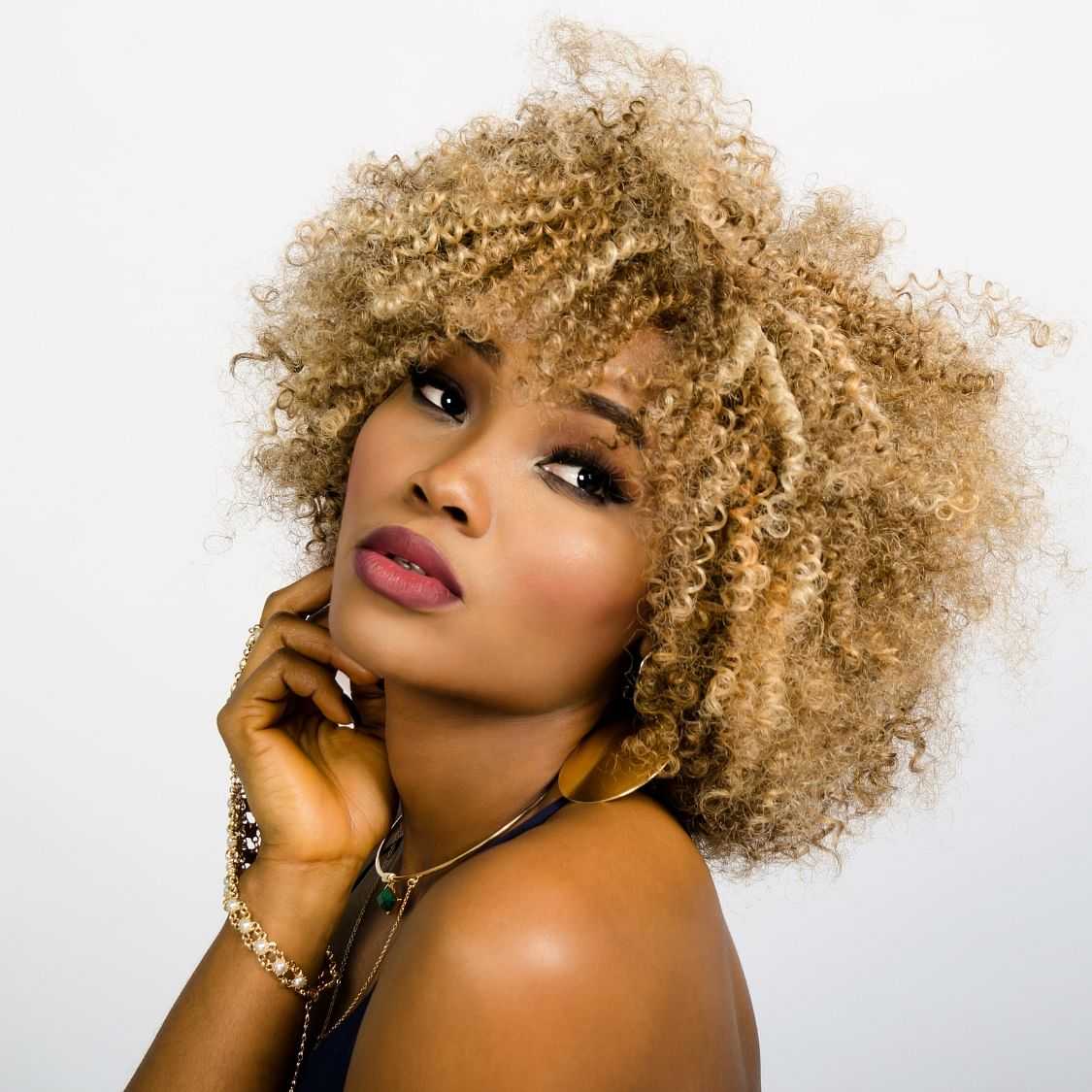 Portrait of a woman with curly hair posing pensively.