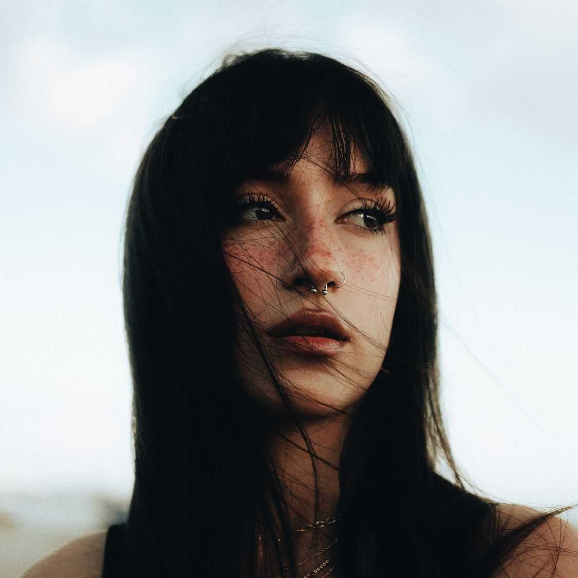 Portrait of a pensive woman with windswept hair.